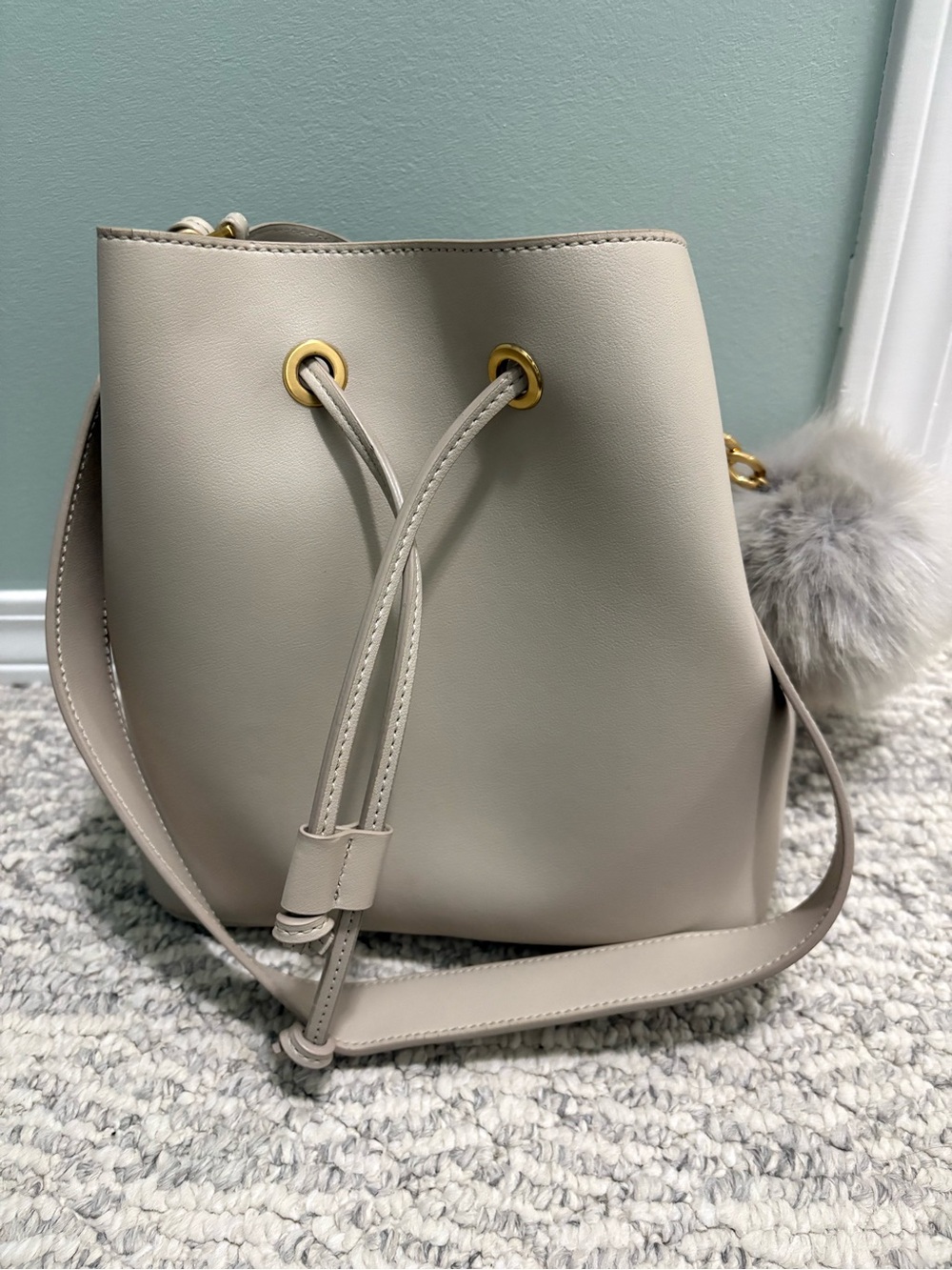 Neutral Cream Drawstring Bucket Bag with Pom Charm